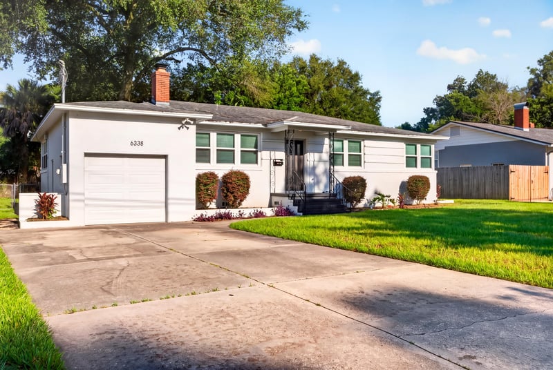Front exterior with driveway and landscaped lawn at 6338 Mercer Cir W, Jacksonville, FL