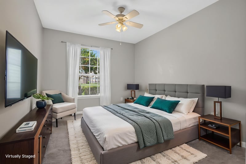 Primary bedroom with staged bed and TV at 7990 Baymeadows Rd E #404, Jacksonville, FL 32256