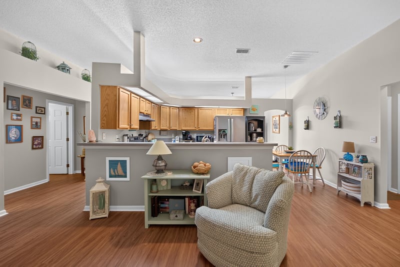 Kitchen island and breakfast bar with living room beyond at 13514 Las Brisas Way N, Jacksonville, FL