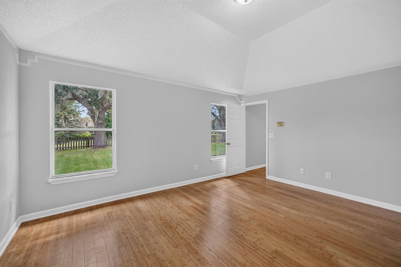 Bedroom with wood floors and two windows at 456 Bay Point Way N, Jacksonville, FL 32259