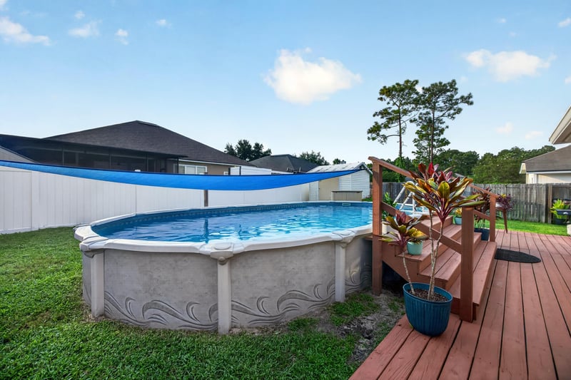 Above-ground pool and wood deck off the side yard at 3112 Silverado Cir, Green Cove Springs, FL 32043