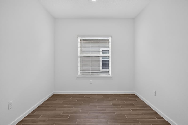 Bedroom with window and wood-look flooring at 9905 Ansley Lake Dr, Jacksonville, FL