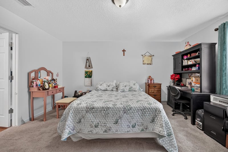 Primary bedroom with sitting desk and wall art at 518 Matecumbe Ct, Macclenny, FL