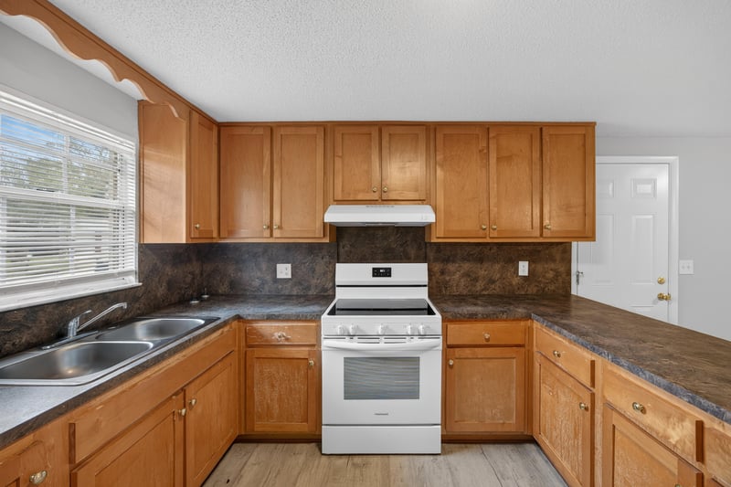 Kitchen range, sink, and wood cabinets at 1435 Undine Ave, Jacksonville, FL
