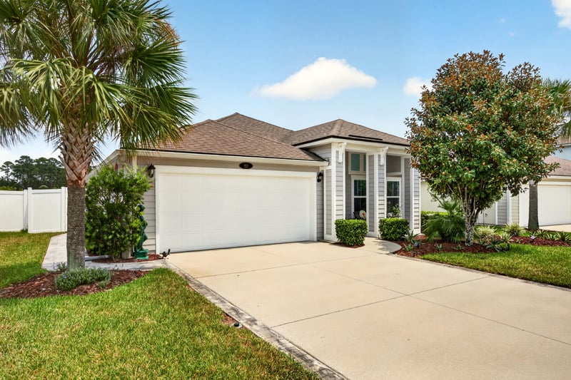 Front exterior view with driveway and mature tree at 85 Amia Dr, St. Augustine, FL 32086