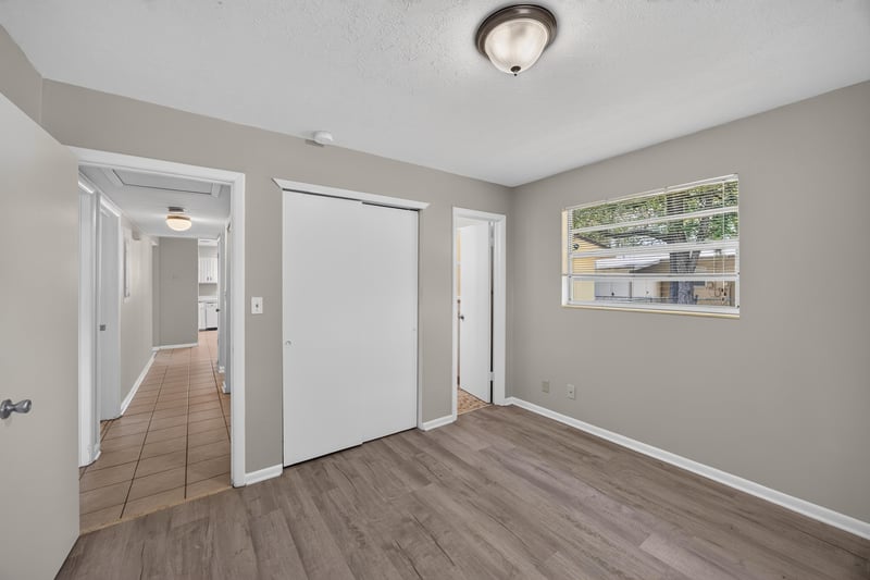 Hallway with wood-look flooring and closet doors at 5527 Beney Rd, Jacksonville, FL 32207