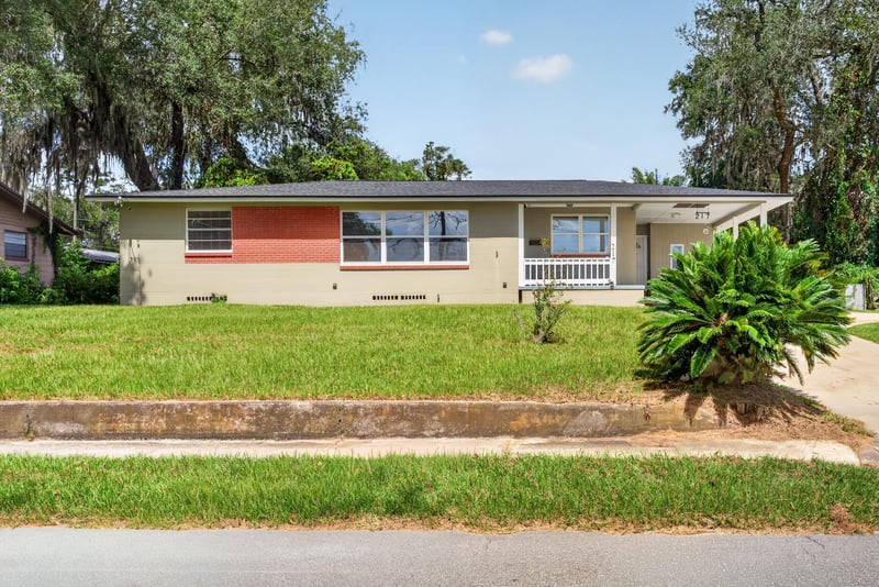 Front elevation showing covered porch and manicured lawn at 217 Baisden Rd, Jacksonville, FL 32218