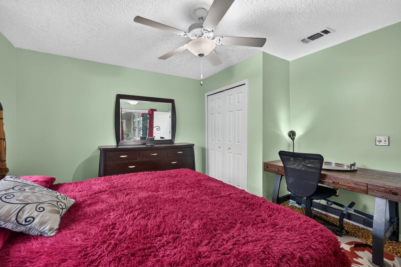 Bedroom with red bedding and desk at 1346 Gately Ct, Jacksonville, FL 32225