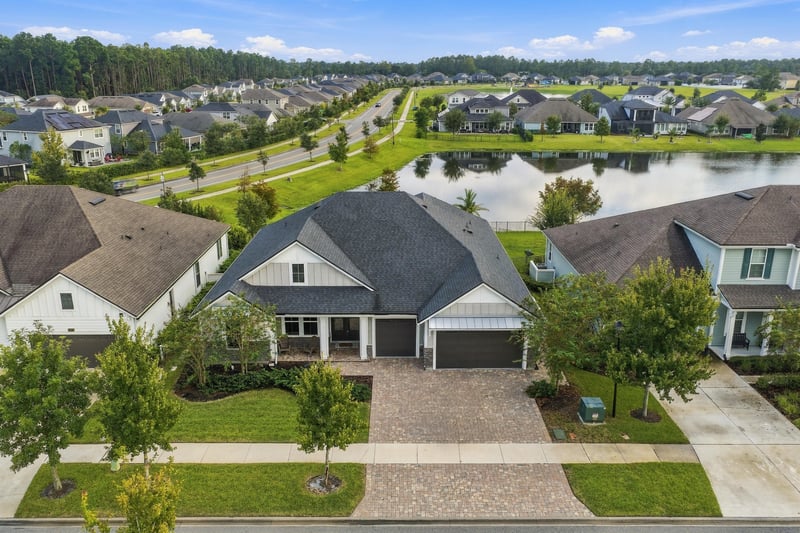 Day-to-dusk aerial of the home and surrounding pond at 3921 Spyglass Hill Ln