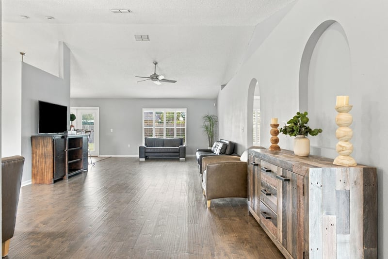 Great room with wood-look floors and archway to kitchen at 11197 Illford Dr