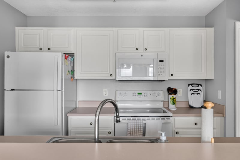 Kitchen with white cabinets, refrigerator and range at 206 16th St, St. Augustine, FL 32080