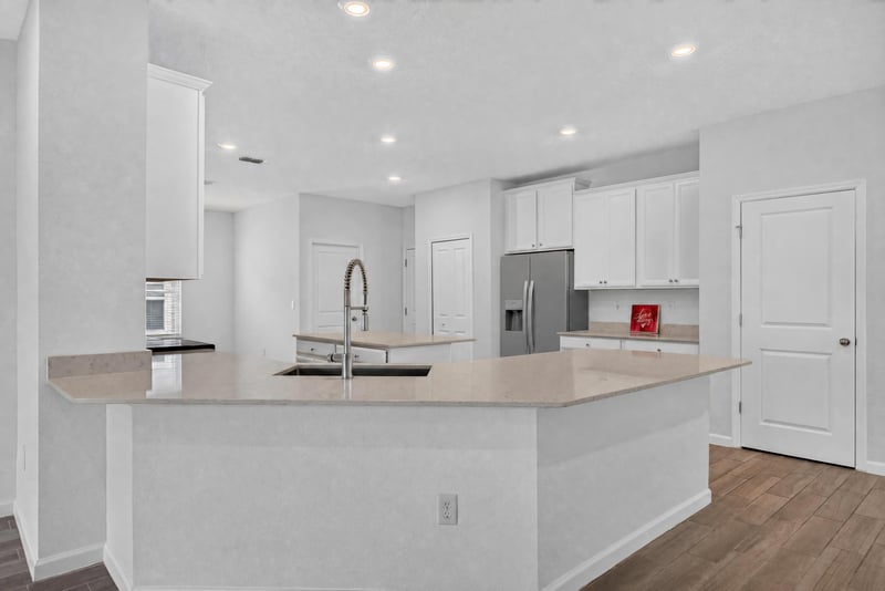 Kitchen with island and stainless appliances, virtually staged at 9905 Ansley Lake Dr, Jacksonville, FL