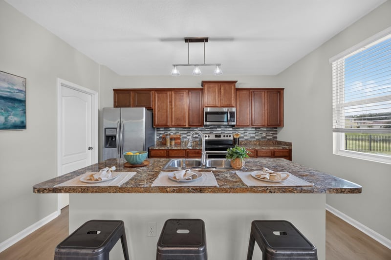 Kitchen with tile backsplash and bar seating at 6830 Hanford St, Jacksonville, FL 32219