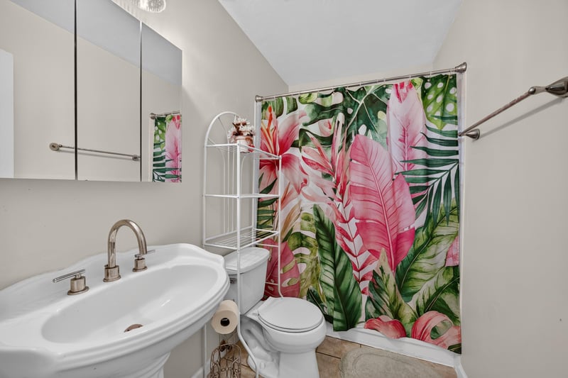 Bathroom with pedestal sink and tropical shower curtain at 2829 Blackberry Ave