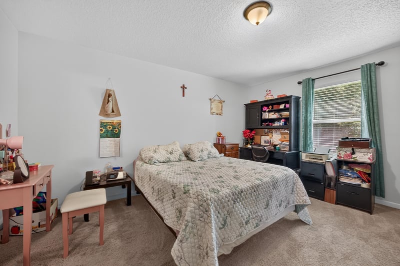 Primary bedroom with carpet and bookshelf at 518 Matecumbe Ct, Macclenny, FL