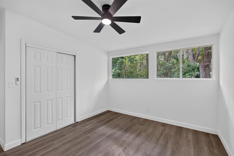 Bedroom with closet door and wood-look flooring at 3113 Kline Rd, Jacksonville, FL 32246