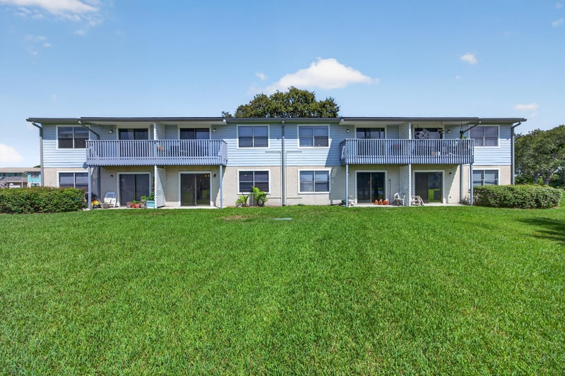 Rear exterior of the condo building with open lawn at 700 W Pope Rd unit h61, St. Augustine, FL 32080