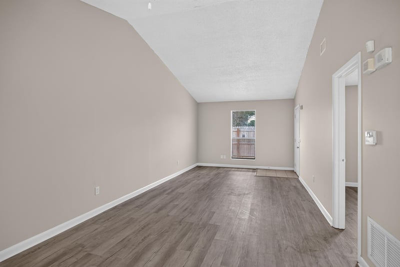 Living area with wood-look floor and interior doorway at 2717 Trollie Ln, Jacksonville, FL