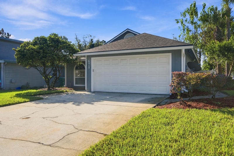 Front exterior with mature trees at 678 5th Ave N, Jacksonville Beach, FL 32250