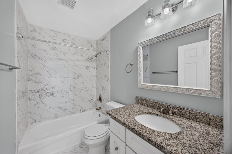 Bathroom with framed mirror and tile surround at 490 Hillside Dr, Orange Park, FL 32073