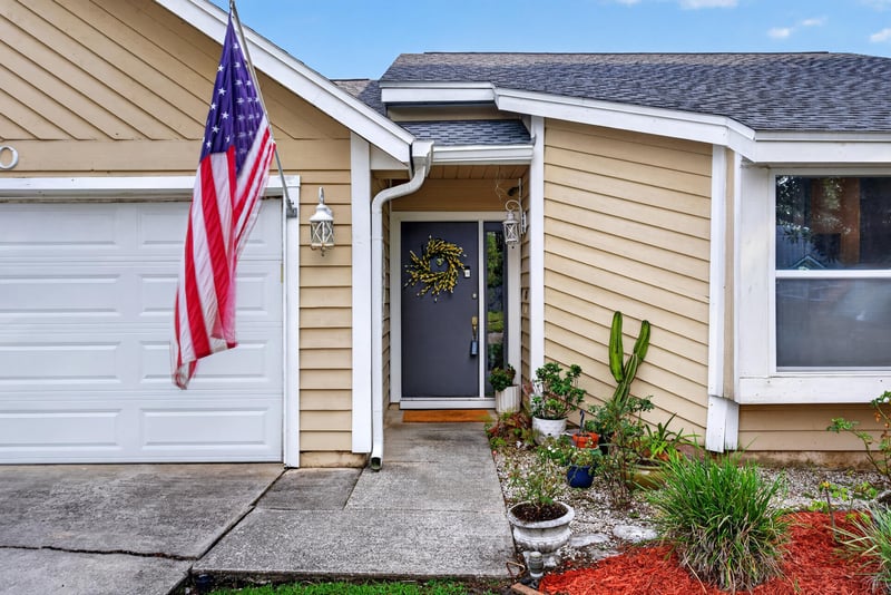 Front door with American flag and planters at 13020 Medford Ln, Jacksonville, FL 32225
