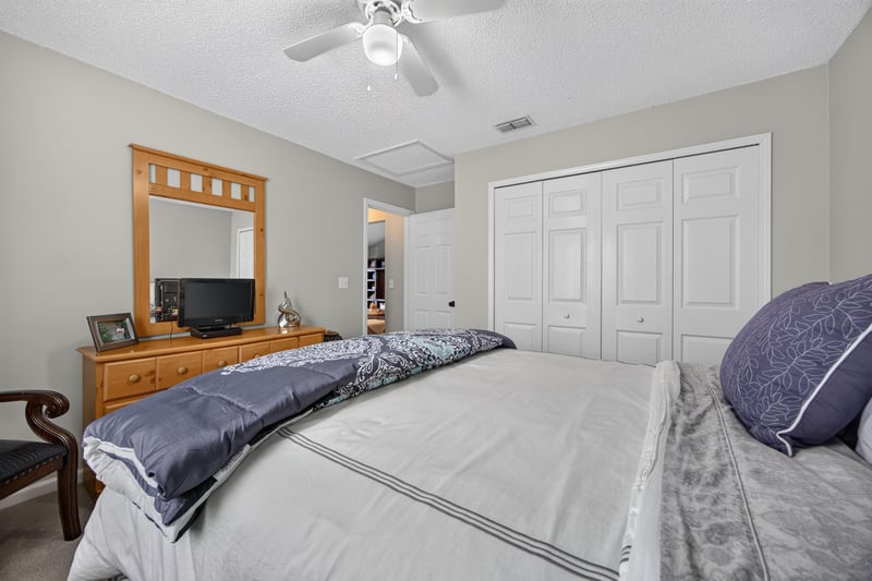 Bedroom with dresser, mirror, and closet doors at 3067 Wavering Ln, Middleburg, FL 32068