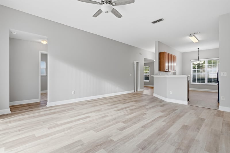 Living room open to kitchen with wood-look flooring at 14187 Big Spring St, Jacksonville, FL 32258