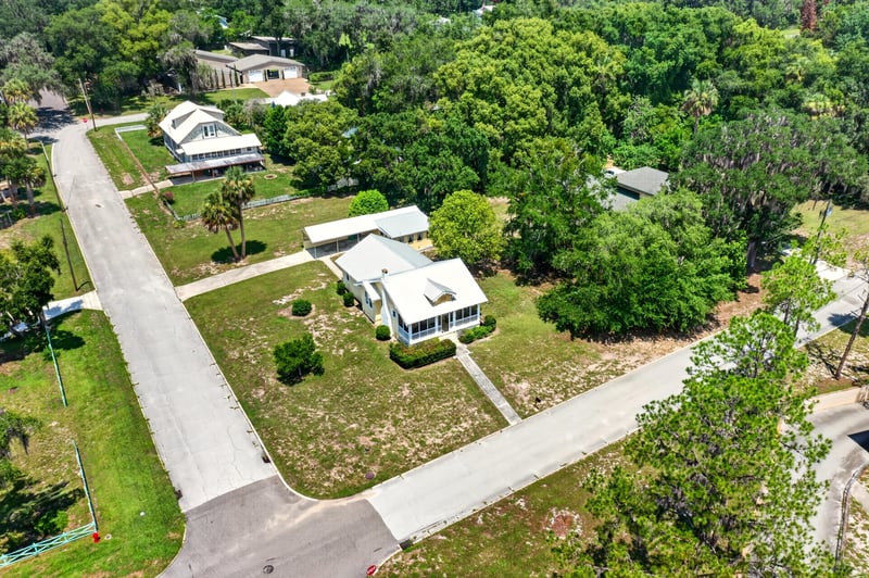 Drone side view of house and tree-lined street at 101 N Lake St, Crescent City, FL