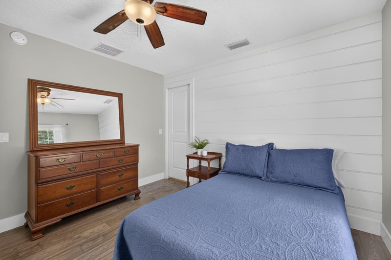 Bedroom with dresser mirror and blue bedding at 1161 Whispering Pines Rd, Jacksonville, FL 32259