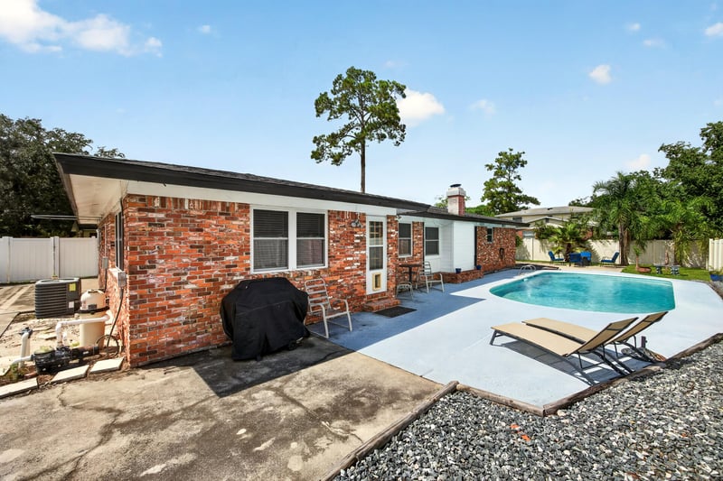 Side exterior view with pool and AC unit at 6059 Karen St, Jacksonville, FL 32244