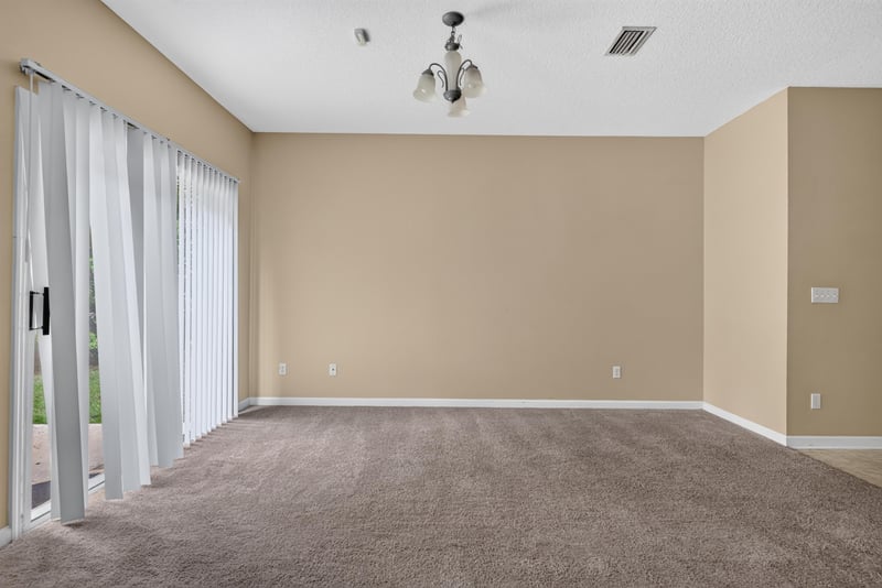Living room with sliding glass door to patio at 12359 Mangrove Forest Ct, Jacksonville, FL 32218