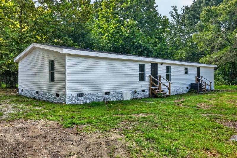 Side exterior with white siding and steps at 55520 Jewel-Thomas Rd, Callahan, FL 32011