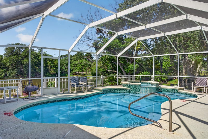 Screened pool enclosure under blue sky at 8680 Bandera Cir S, Jacksonville, FL 32244
