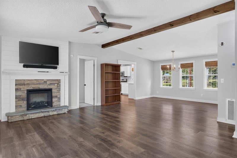 Living room with fireplace and beamed ceiling at 4890 McAllister Rd, Middleburg, FL 32068
