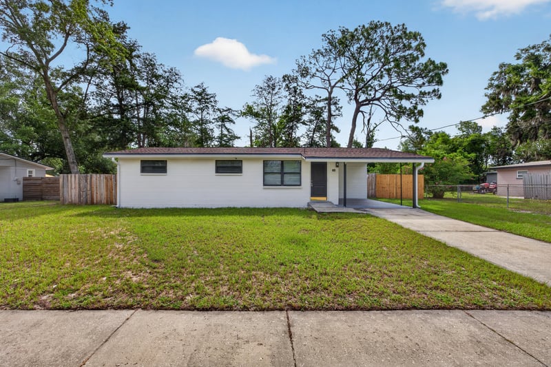 Front exterior, white brick ranch home with long driveway and lawn at 184 Draco St, Orange Park, FL 32073