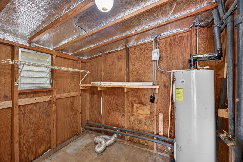 Utility room with water heater and wood shelving at 5527 Beney Rd, Jacksonville, FL 32207