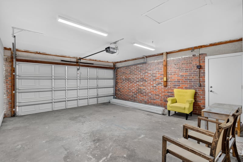 Two-car garage interior with staged seating at 8453 Boysenberry Ln W, Jacksonville, FL