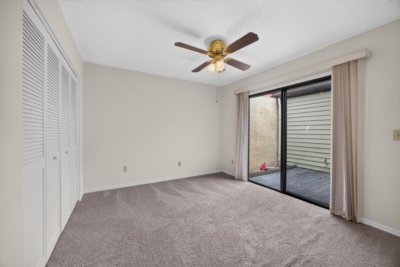 Empty bedroom with carpet and sliding glass doors at 3407 Fairbanks Grant Rd N, Jacksonville, FL 32223