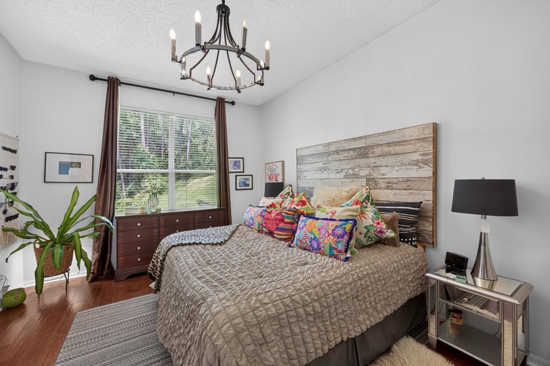 Primary bedroom with wood headboard and windows at 1820 Burgess Hill Dr E, Jacksonville, FL