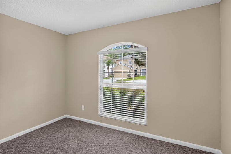 Carpeted bedroom with arched window at 469 Glendale Ln, Orange Park, FL