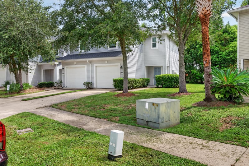 Front exterior with driveway and landscaped entry at 12359 Mangrove Forest Ct, Jacksonville, FL 32218