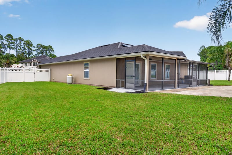 Backyard with screened porch and lawn at 706 Grampian Highlands Dr, St. Johns, FL 32259