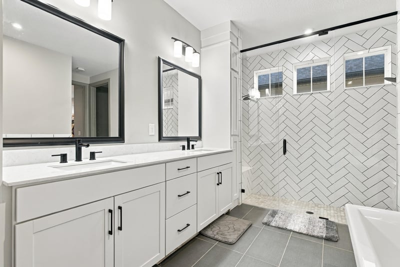 Primary bathroom double vanity with framed mirrors at 3921 Spyglass Hill Ln