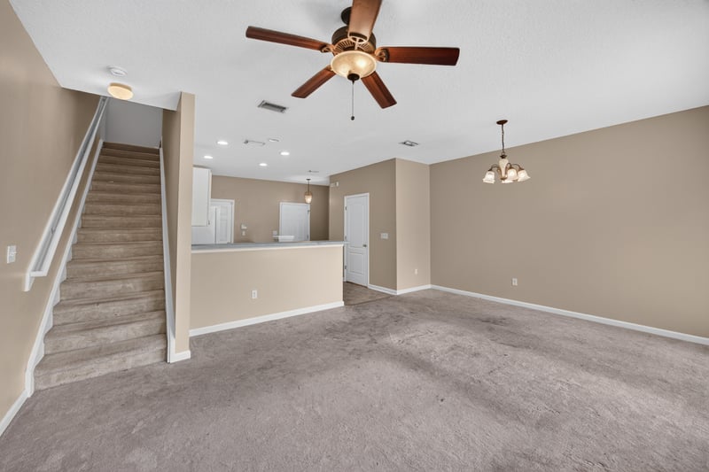 Living room near staircase with carpet and ceiling fan at 1572 Biscayne Bay Dr, Jacksonville, FL 32218