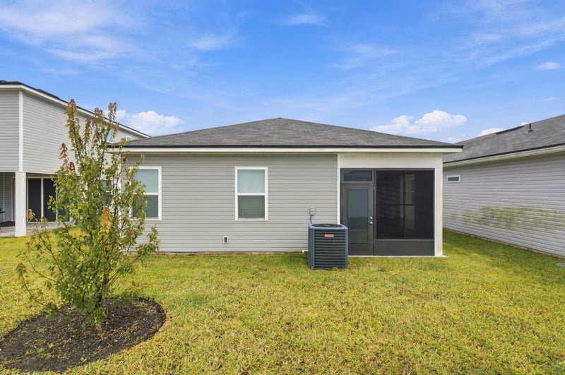 Rear exterior with screened porch and AC unit at 7088 Mahogany Run Dr, Jacksonville, FL 32244