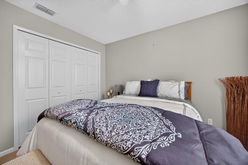 Bedroom with patterned bedding and ceiling fan at 3067 Wavering Ln, Middleburg, FL 32068