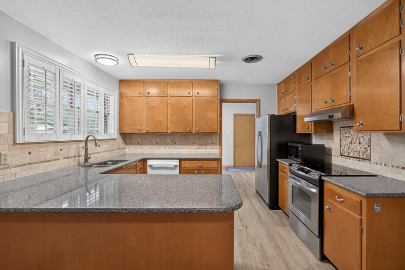 Kitchen with wood cabinets and granite island at 1834 Memory Ln, Jacksonville, FL
