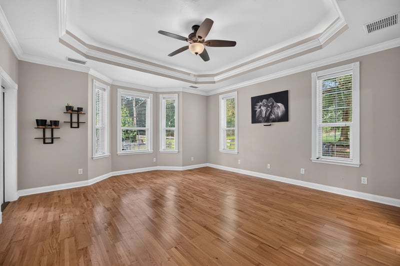 Primary bedroom with hardwood floors and tray ceiling at 1735 Hagans Ridge Ct