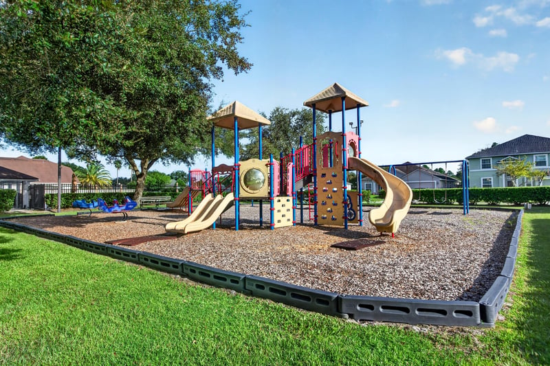 Playground with climbing equipment and open lawn in Johns Creek
