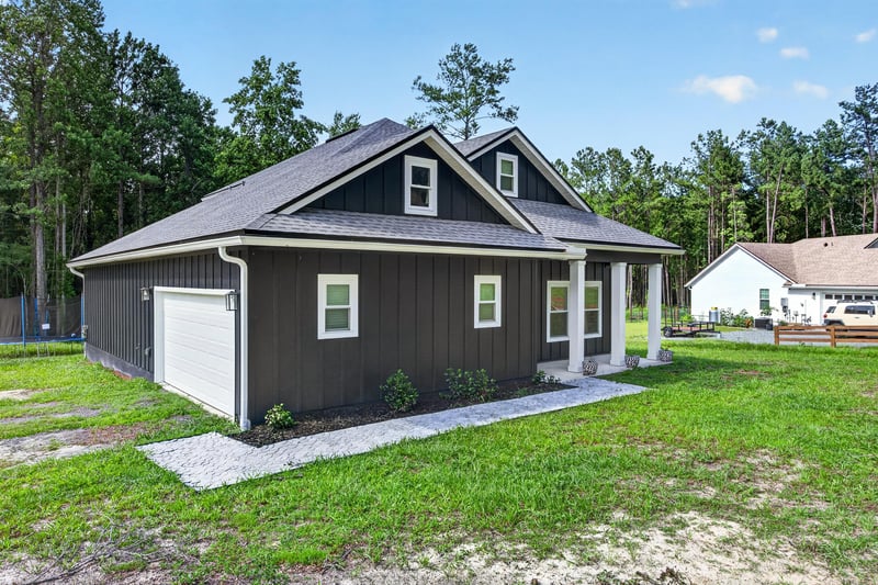 Front exterior with attached garage and gray roof at 2817 Camel Cir, Middleburg, FL